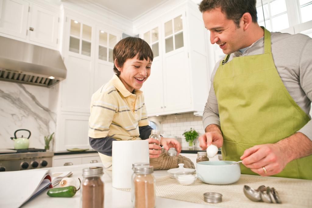 сын и отец готовят на кухне еду