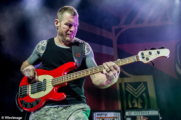 Personal loss: Rage Against the Machine/Audioslave bassist Tim Commerford and his wife have split after 17-years of marriage; he is pictured playing with supergroup Prophets of Rage