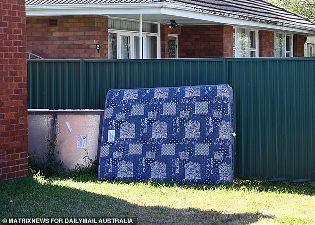 An old mattress is plonked outside the front of the home, exposed to the elements