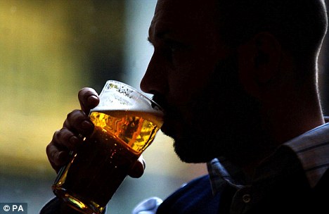 A man drinking a pint of lager in a pub
