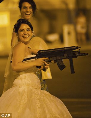 a Romanian bride holds toy weapons at the Triumph Arch in Bucharest, Romania