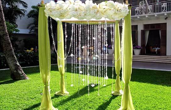 Свадебная арка из цветов и зеленой ткани