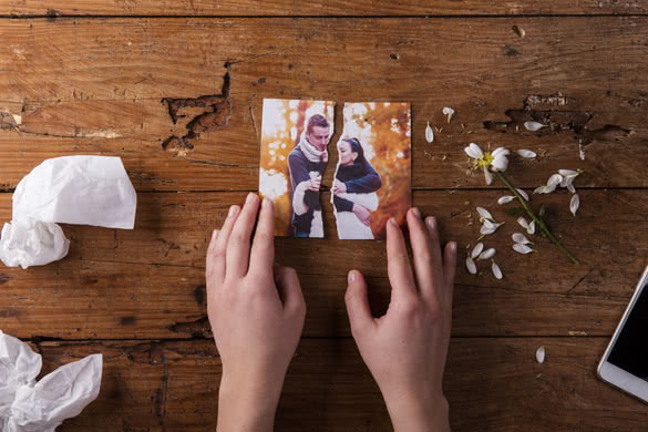Unrecognizable sad woman holding torn picture of couple in love